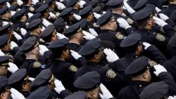 New York City Police Officers salute following the funeral service for New York City Police Officer Wenjian Liu during his funeral service at Aievoli Funeral Home in the Dyker Heights neighborhood on January 4, 2015 in the Brooklyn borough of New York City.