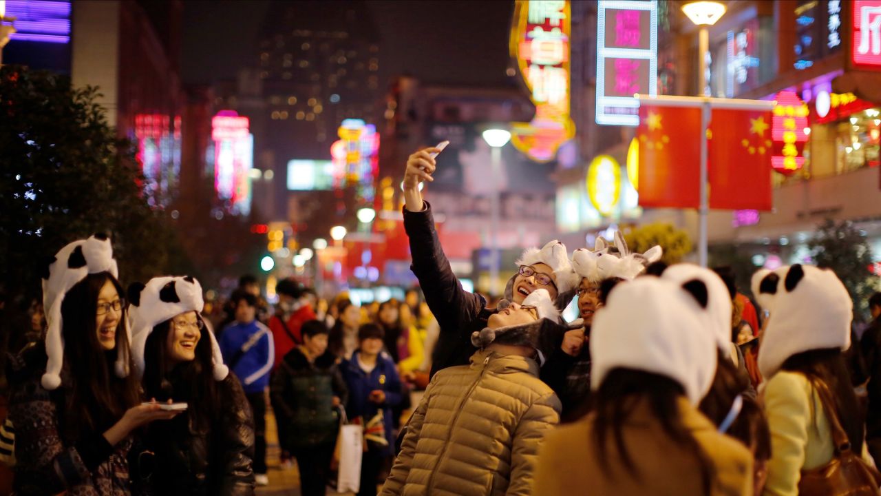 Tourists wearing panda hats take a selfie during a New Year's celebration in Shanghai, China, on Thursday, January 1.