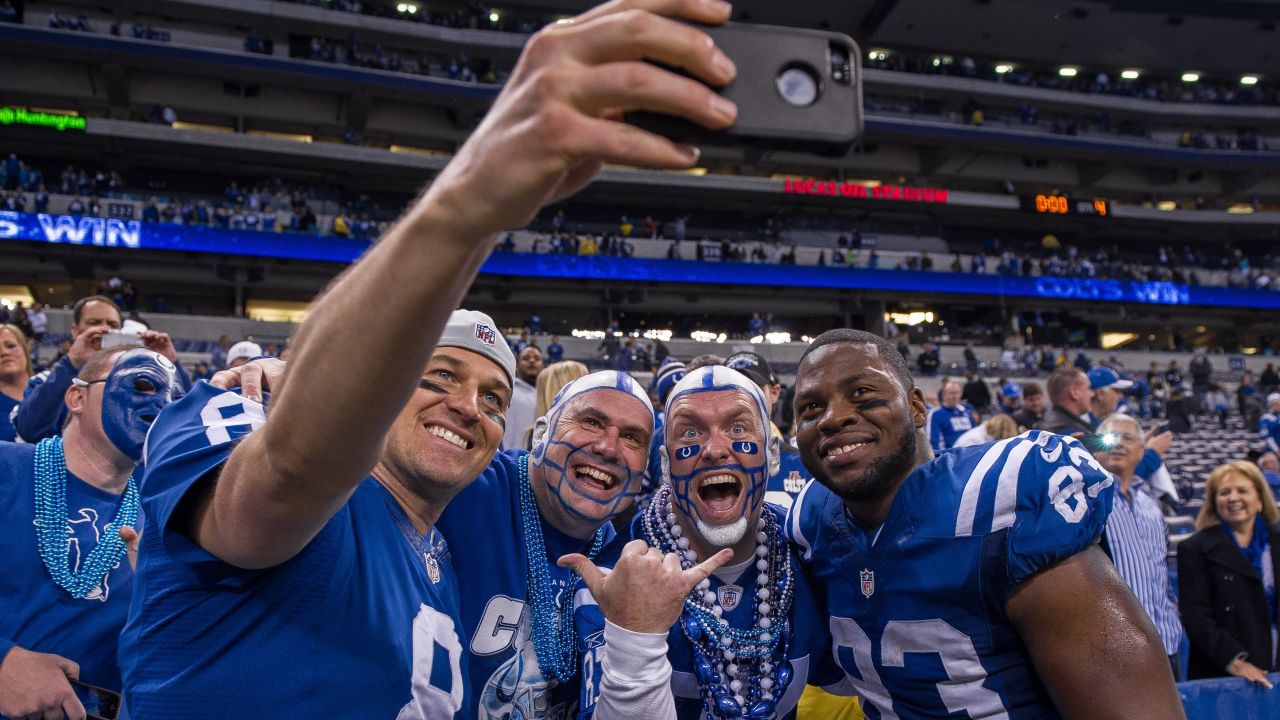 Indianapolis Colts quarterback Matt Hasselbeck snaps a photo with teammate Dwayne Allen, right, and two fans after the Colts defeated Cincinnati in a playoff game Sunday, January 4, in Indianapolis.