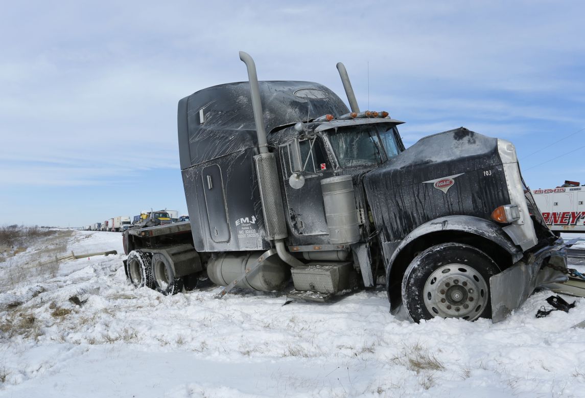 A truck remains on the side following a crash involving several vehicles on January 6, a few miles south of Remington, Indiana. The highway's southbound lanes were iced over following a winter storm that swept across Indiana overnight. 