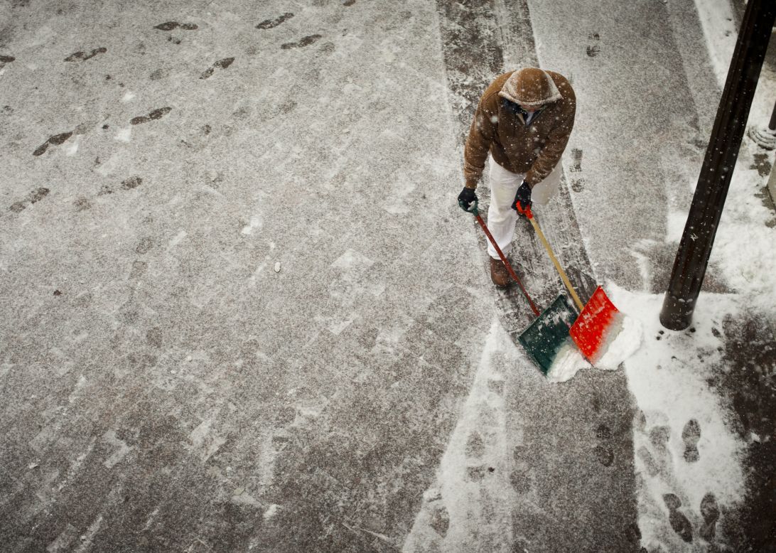 A worker helps clear the sidewalk entrance to the U.S. Capitol in Washington on January 6.