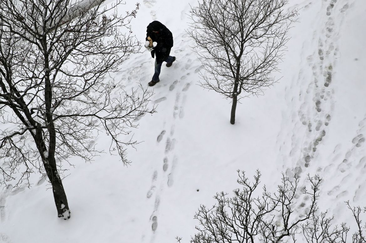 A man walks on a snow-covered sidewalk on Tuesday, January 6, in Baltimore. <br />
