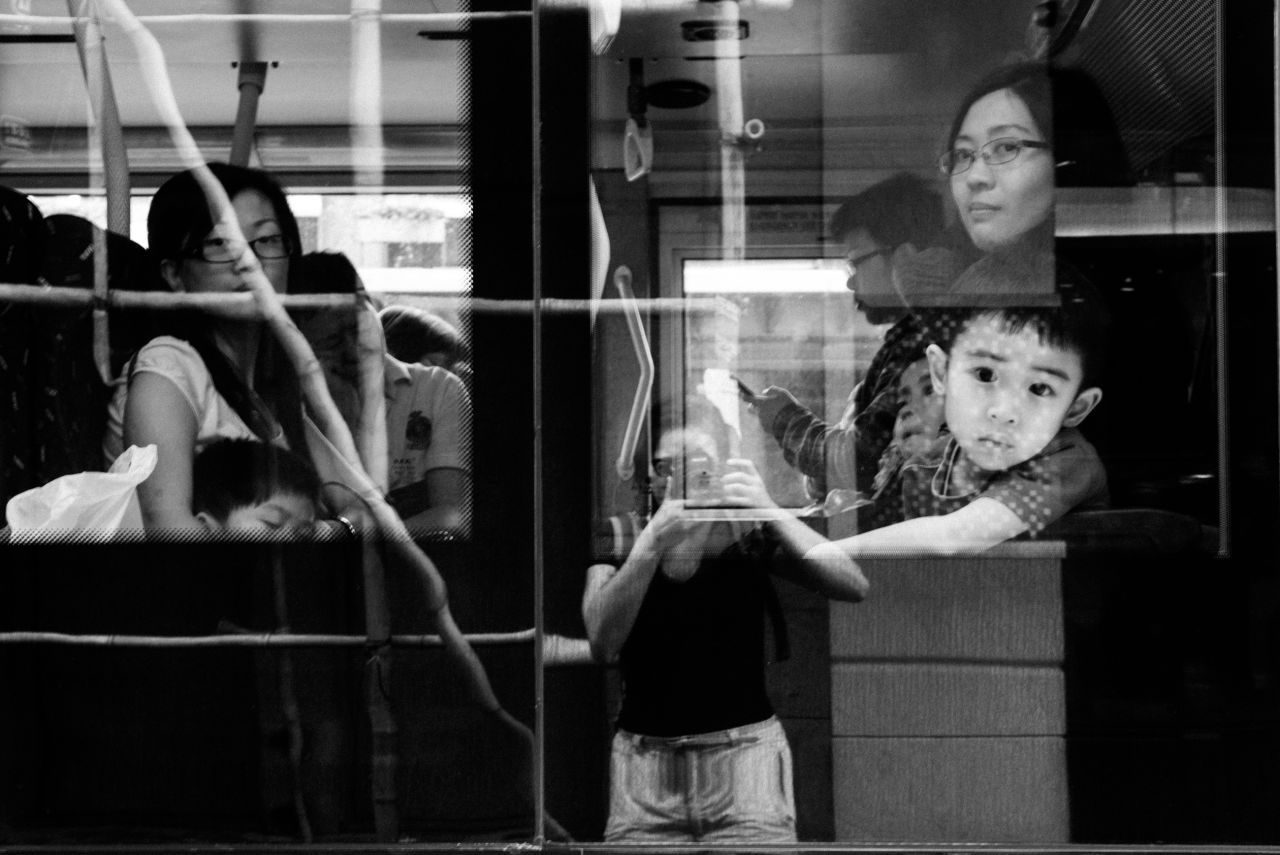 Bacani catches her reflection on a bus in Causeway Bay, one of Hong Kong's busiest shopping districts. She has lived in the city for nine years and still doesn't feel like she belongs. "When you're a helper, you don't have a right to be a photographer," she says.