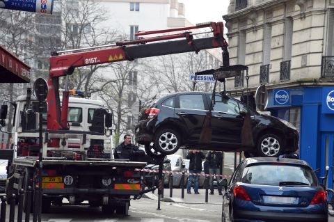 A tow truck lifts the car used by the gunmen.