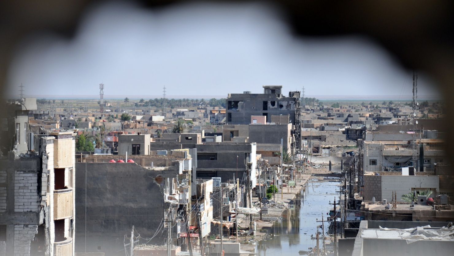 Taken through a hole in a wall, this file photo from June 2014 shows the damage caused by conflict between government forces and anti-government militants in the Anbar capital of Ramadi in Iraq.