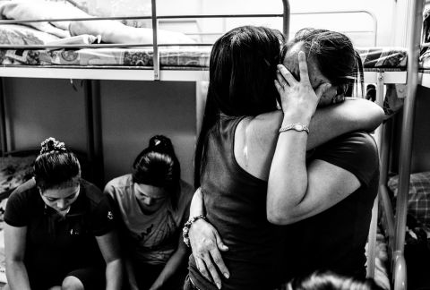 Two women comfort each other during a sharing session at Bethune House Migrant Women's Refuge, a shelter for abused domestic workers in Hong Kong. Xyza Cruz Bacani works as a maid six days a week and spends her day off documenting their stories in a series of black and white images.