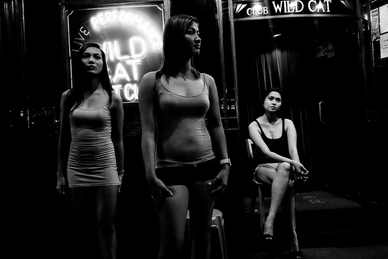 Women wait outside Wild Cat Night Club on Lockhart Road in Wan Chai, Hong Kong's red-light district. Bacani spends six days a week cooking, cleaning and babysitting for an affluent Chinese family. On her day off, she wanders around the city capturing black and white scenes.