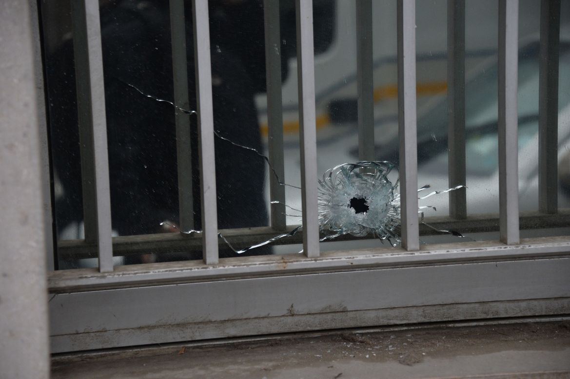 A bullet hole is seen in a window of the magazine's building.