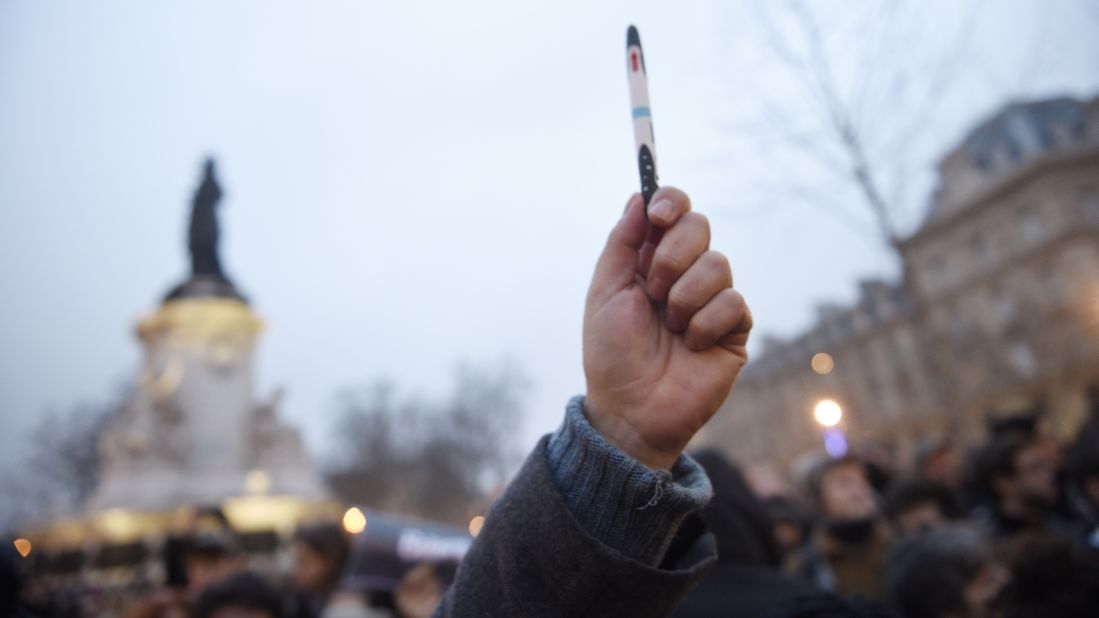 A man in Paris raises a pen on January 7.
