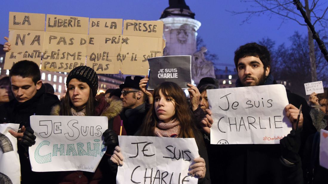 People hold signs during a gathering in Paris on January 7.
