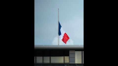 The French national flag flies at half-staff on the roof of the French Embassy in Berlin.
