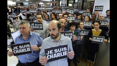Journalists with Agence France-Presse hold signs reading "I am Charlie" as they observe a minute of silence on January 7.