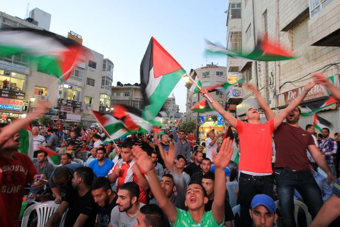 Palestinians celebrate in the West Bank city of Ramallah on May 30, 2014, after their team qualified for their maiden Asian Cup appearance with a 1-0 win over injury-hit Philippines in the final of the AFC Challenge Cup in Maldives.