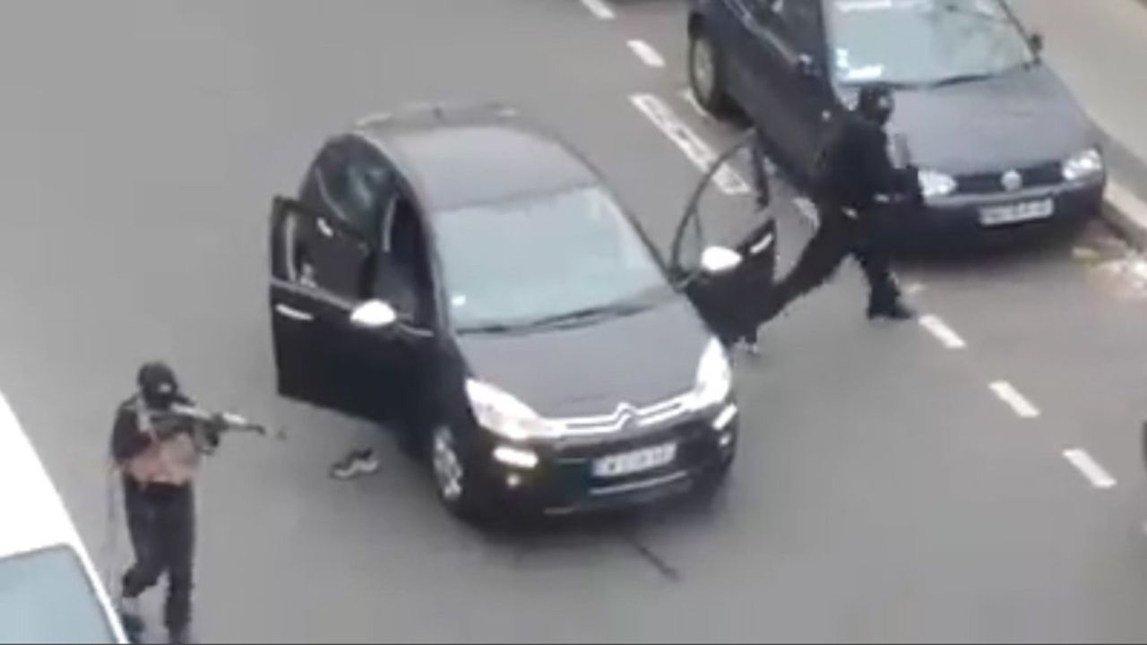 Gunmen step out of a car to shoot and kill a police officer near the Charlie Hebdo office on January 7.