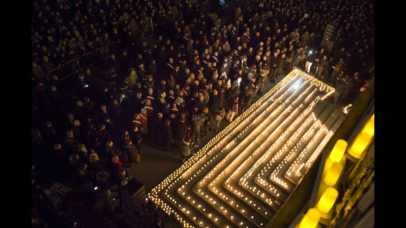 People gather near candles in Lyon, France, on January 7.
