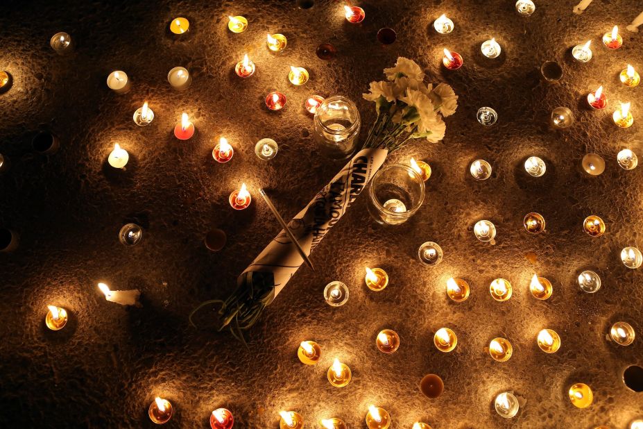 Flowers are placed at a candlelight vigil near the French Embassy in Tunis, Tunisia, on January 7.