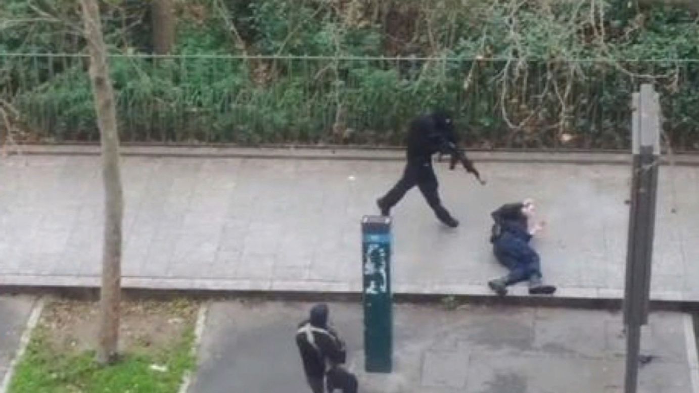 Masked gunmen run toward a victim.
