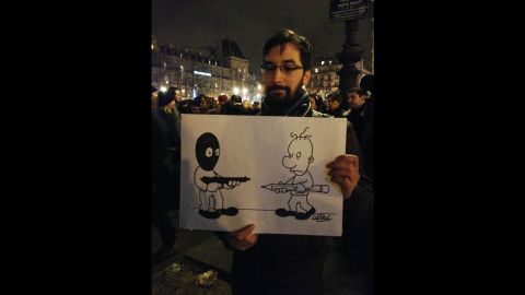 Luc Lemoine carries a cartoon of his making.