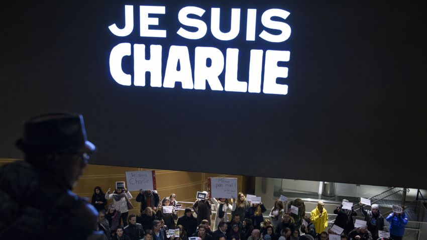 People hold signs with words reading 'Je Suis Charlie' (I Am Charlie) beneath an electronic display echoing the sentiment outside the Newseum January 7, 2015 in Washington, DC in solidarity with the victims of the shooting at the Paris office of the satirical newspaper Charlie Hebdo by three gunman that took the lives of 12 people. AFP PHOTO / BRENDAN SMIALOWSKI (Photo credit should read BRENDAN SMIALOWSKI/AFP/Getty Images)