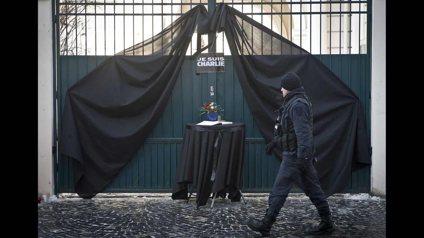 A Romanian military member walks past a condolence book outside the French Embassy in Bucharest, Romania, on January 8.