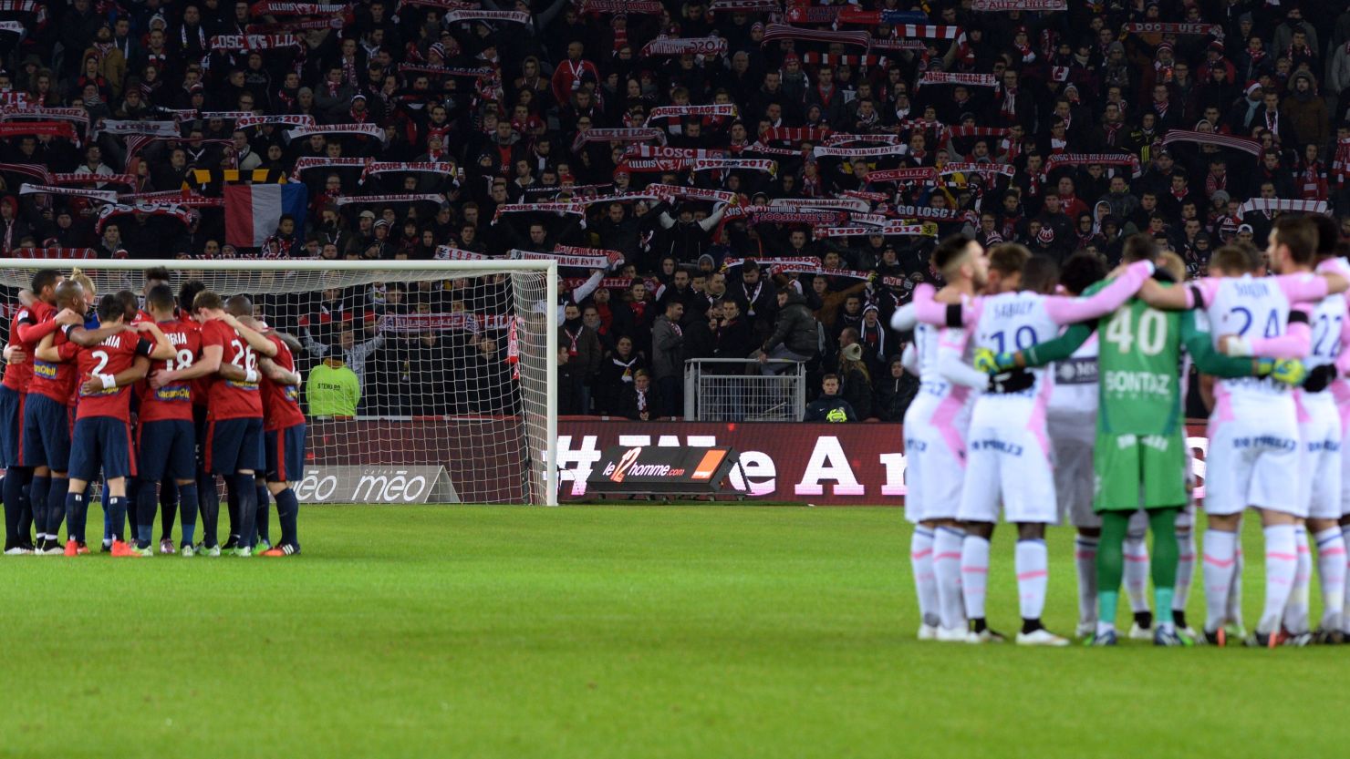 Evian's and Lille's players observe a minute's silence for the victims of the attack on a French satirical magazine.