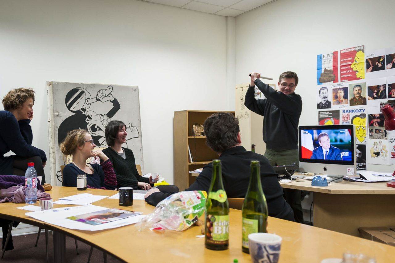 Charlie Hebdo editor and cartoonist Stephane Charbonnier swings a bat at a screen with former French President Nicolas Sarkozy on it during the 2012 French elections. Photographer Steven Wassenaar spent four days with the magazine's staff that year.