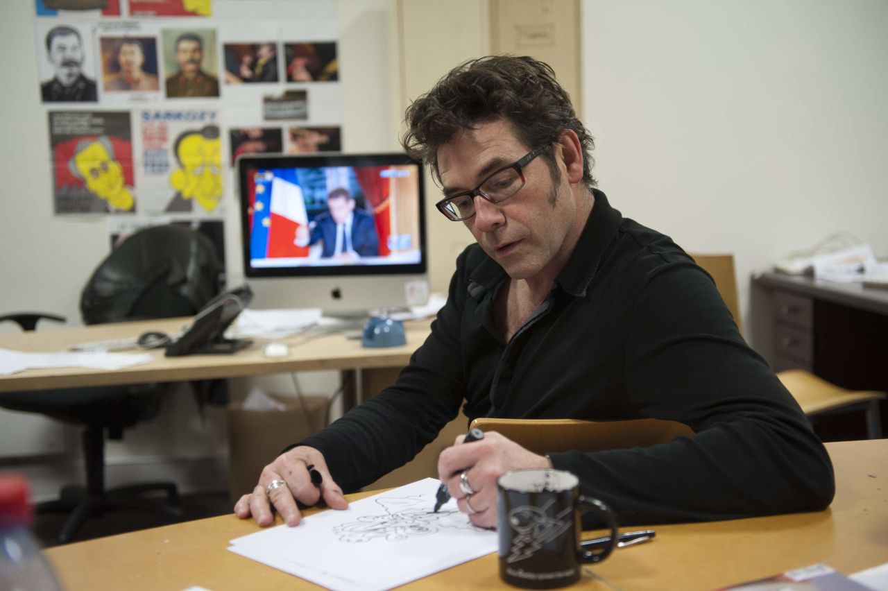 Another one of the shooting victims, cartoonist Bernard "Tignous" Verlhac, sketches a political cartoon in 2012.