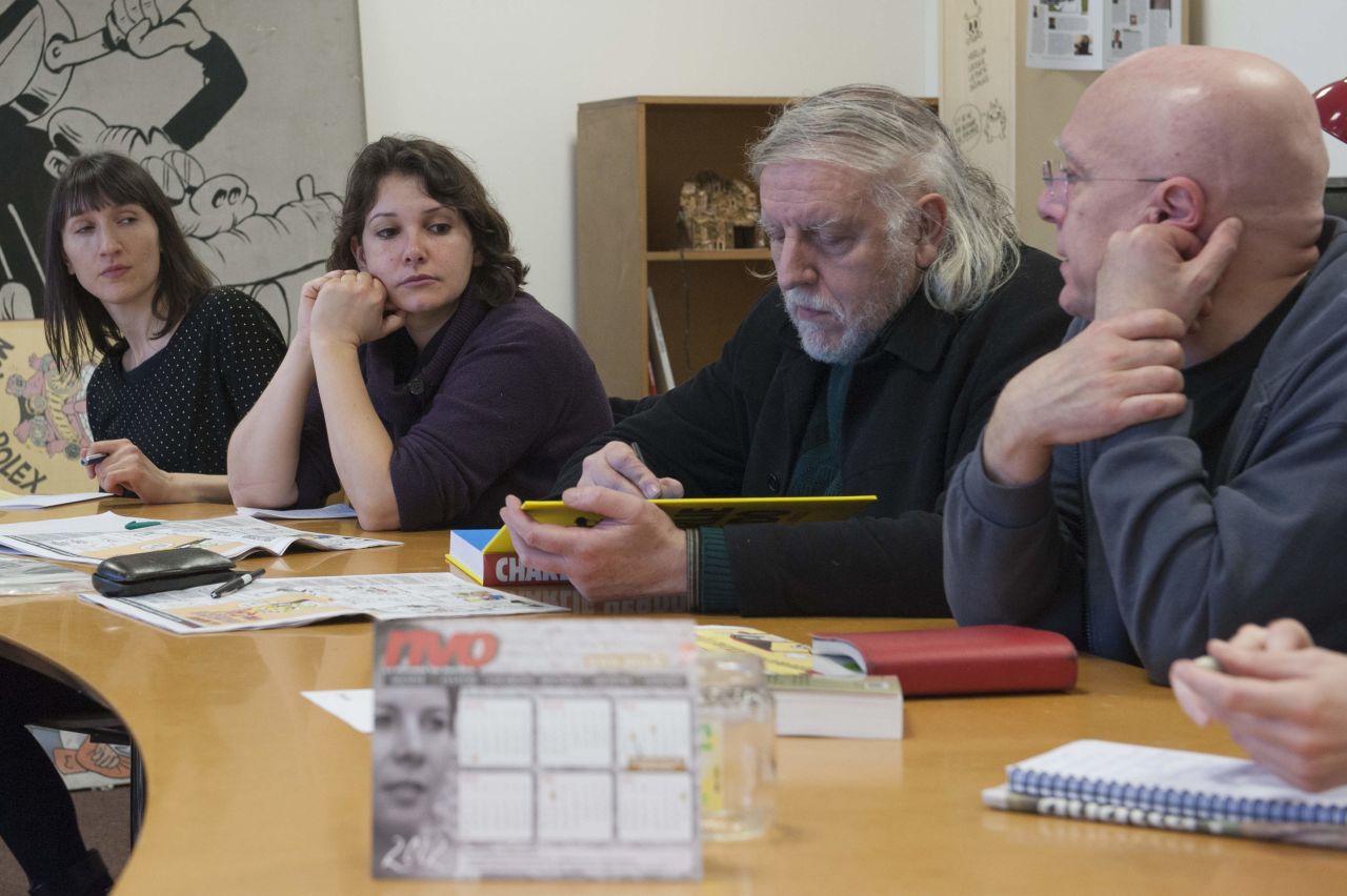 Cartoonist Philippe Honore, second from right, meets with other staff members in 2012. Honore, who illustrated a cartoon featured on Charlie Hebdo's Twitter feed Wednesday morning, was among those killed in the attack. The cartoon is a drawing of ISIS leader Abu Bakr al-Baghdadi offering his best wishes for 2015.