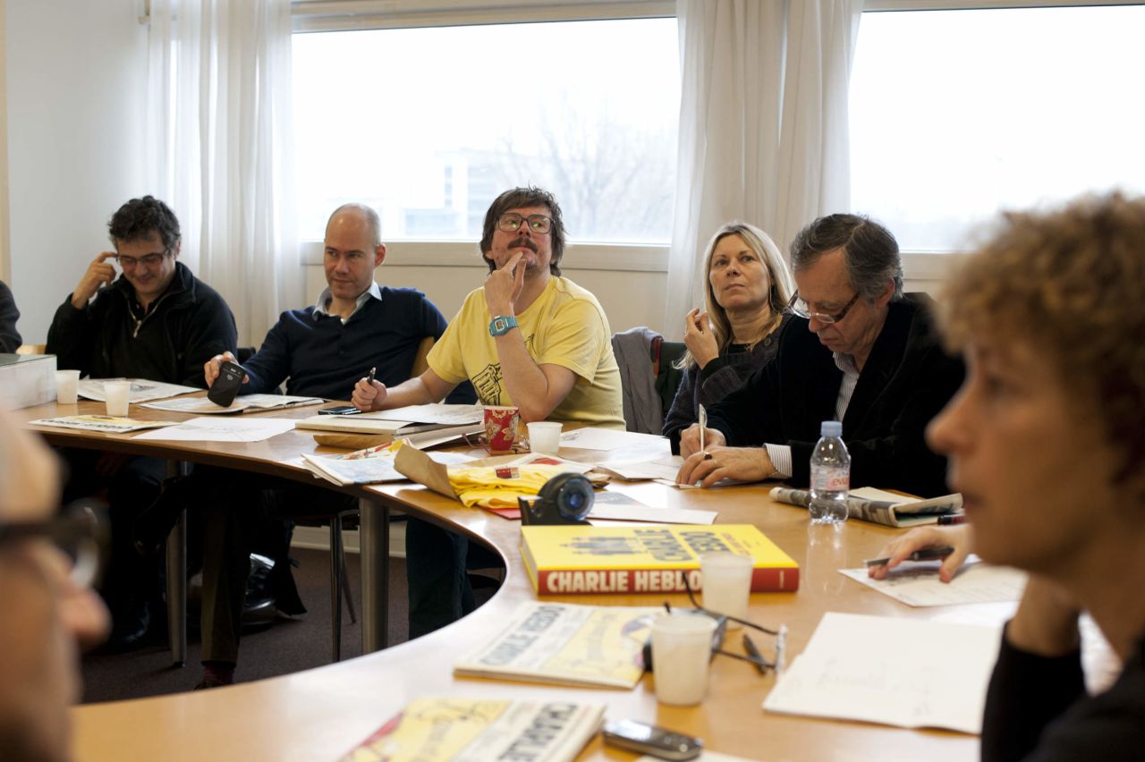 Maris, second from right, sketches during an editorial meeting.