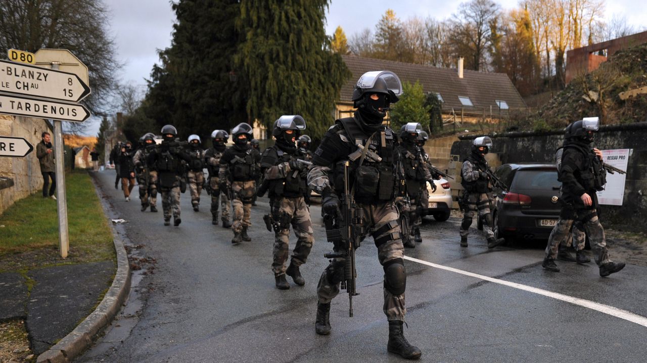 Police walk down a street in Corcy, France, on January 8.