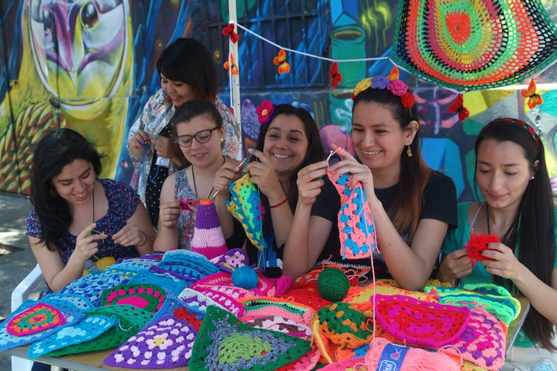 Members of Santiago-based yarn-bombing group Lanaattack (Wool Attack) crochet covers for bicycle saddles at an open air intervention in Barrio Italia, Santiago. 