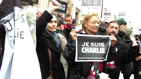People take to the streets in Paris for a vigil to honor victims of the attack on Charlie Hebdo magazine.