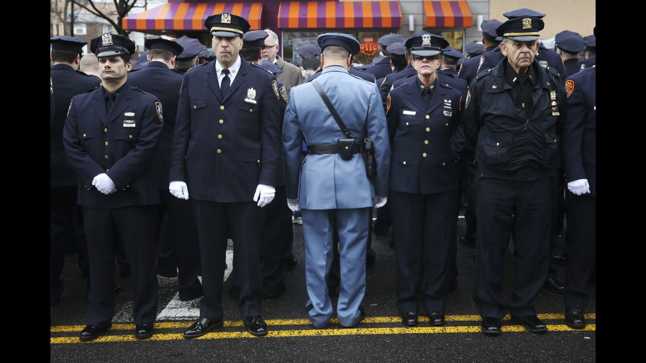 Law enforcement officers stand outside <a href="http://www.cnn.com/2015/01/04/us/gallery/liu-funeral/index.html" target="_blank">the funeral of fallen New York police officer Wenjian Liu</a> on Sunday, January 4. Some officers turned their backs while New York Mayor Bill de Blasio spoke on a monitor. <a href="http://www.cnn.com/2014/12/22/politics/de-blasio-police-shooting/index.html" target="_blank">The mayor's critics</a> believe his comments after the death of Eric Garner contributed to an anti-police sentiment that led to the shootings of Liu and his partner, Rafael Ramos.