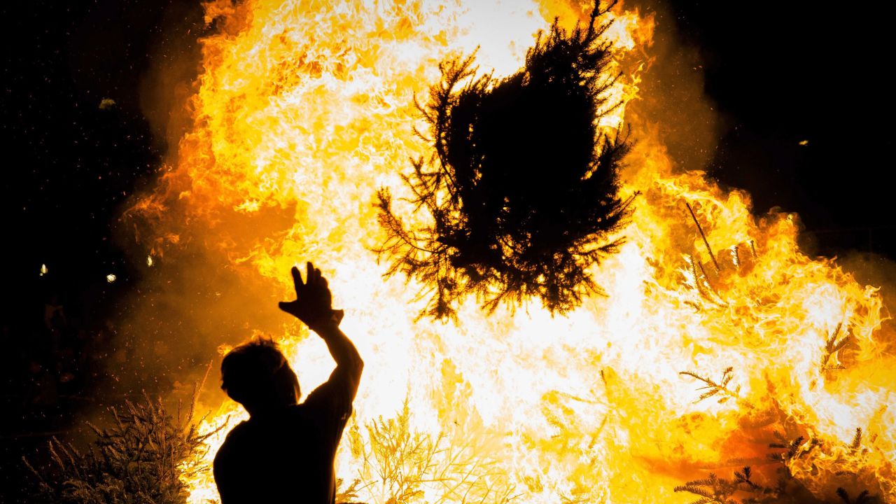 A man throws a Christmas tree onto the annual bonfire at the Museumplein in<br />Amsterdam, Netherlands, on Sunday, January 4.