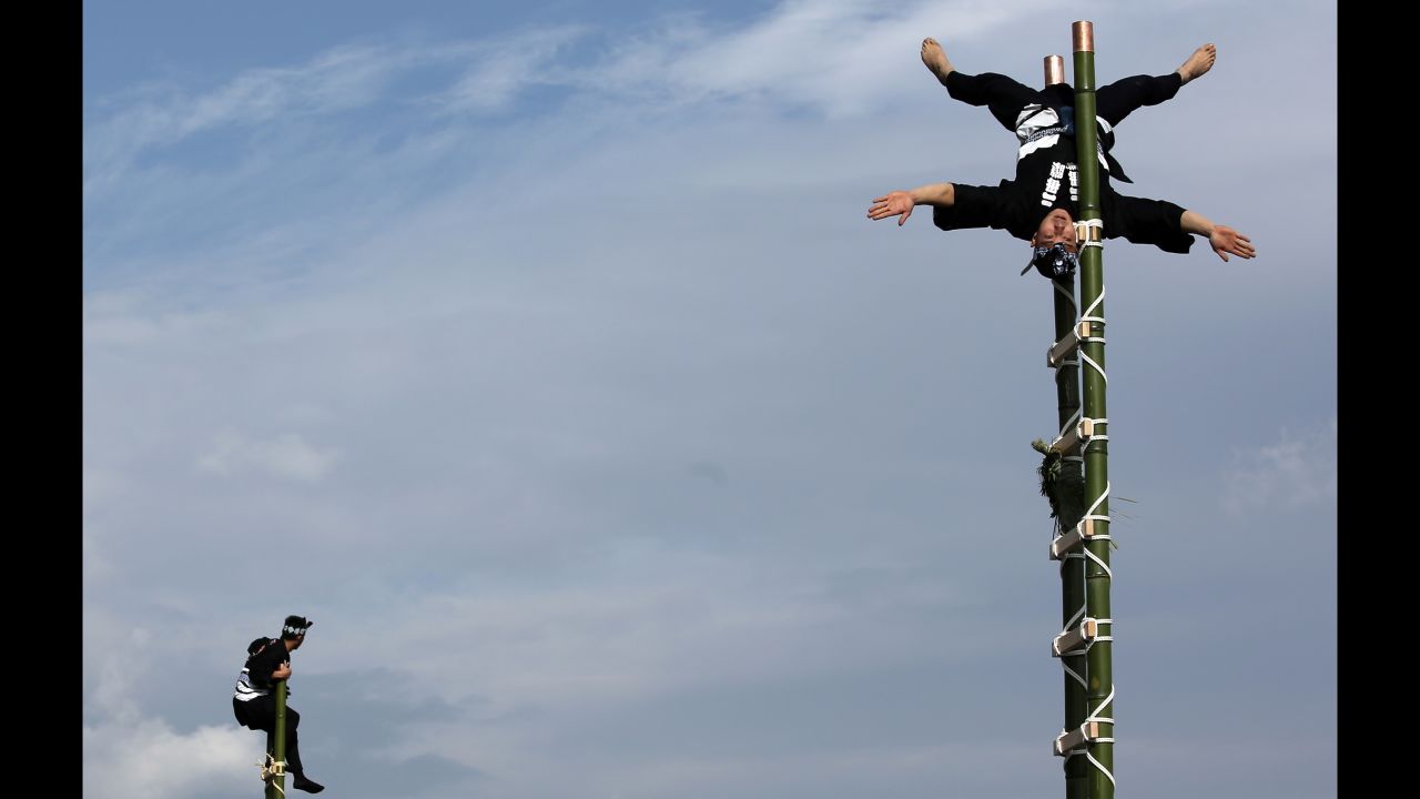 Members of a traditional firefighting preservation group perform ladder stunts Tuesday, January 6, during the annual New Year's Fire Brigade Review in Tokyo.