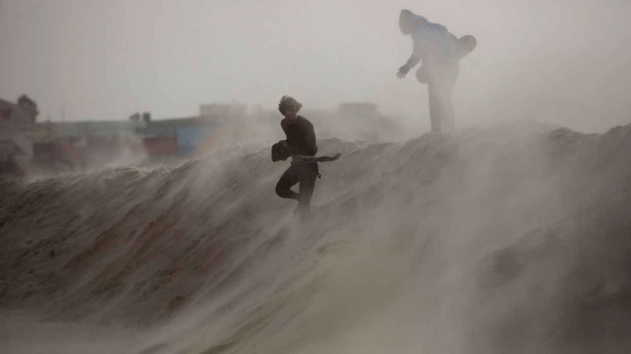 Kids play on a sand hill in Tel Aviv, Israel, that was made to block high waves ahead of a storm on Tuesday, January 6.