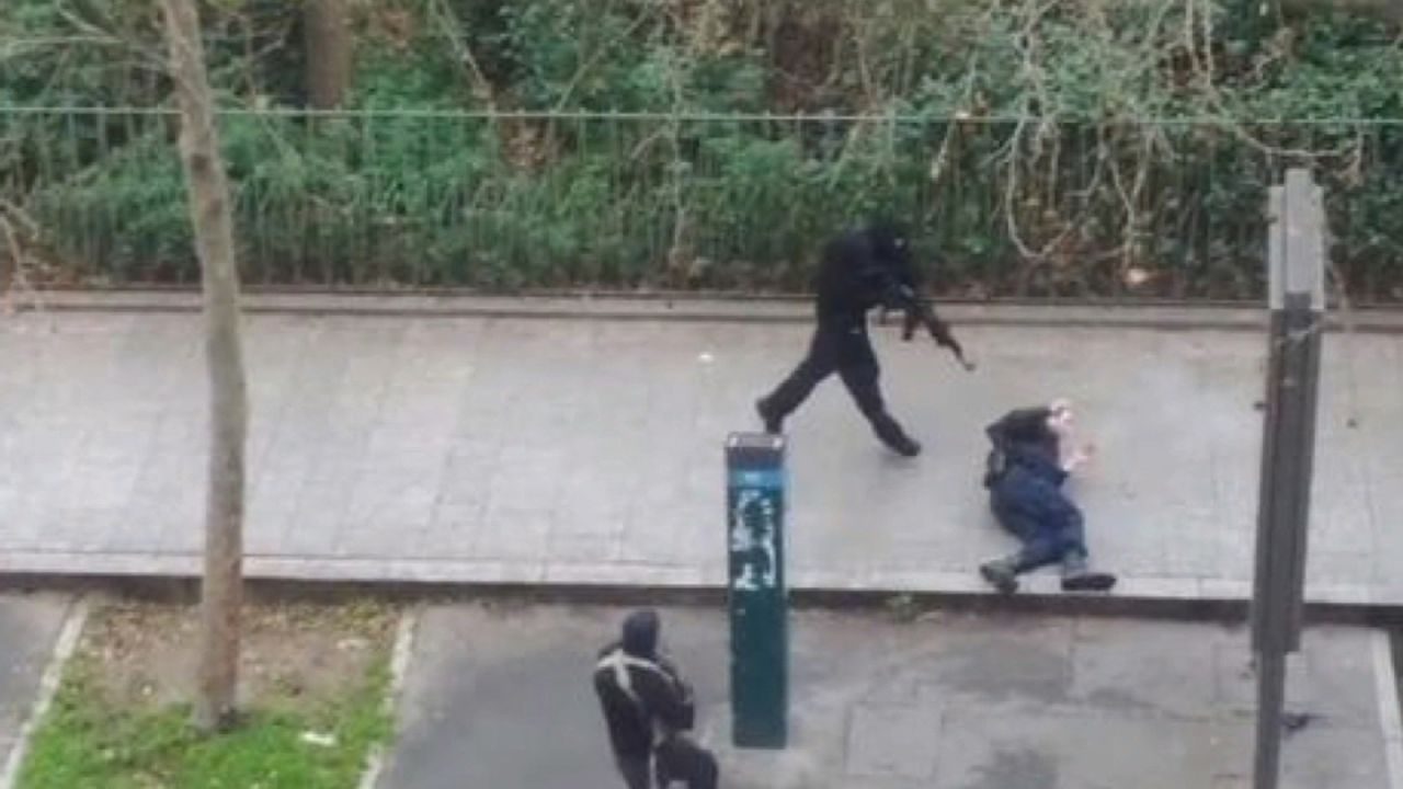 Masked gunmen run toward a victim in the Paris terror attack on Wednesday, January 7.