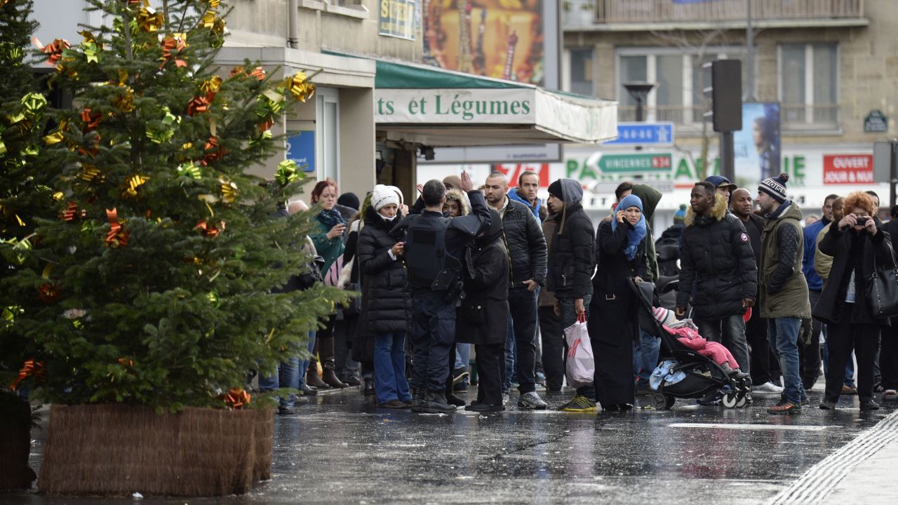 A police officer gives instructions to local residents in Saint-Mande, which is near Porte de Vincennes.