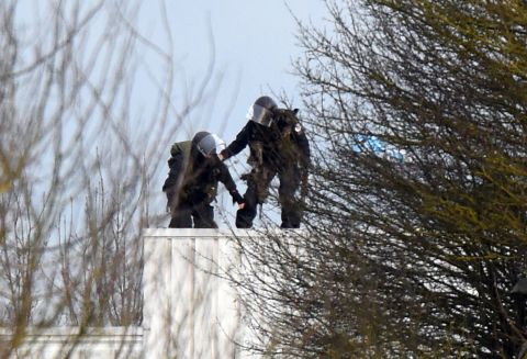 Police take position on a roof during the standoff.