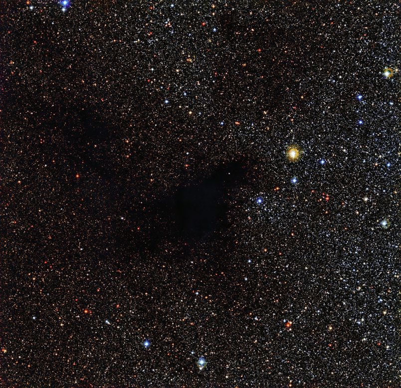 A patch of stars appears to be missing in this image from the La Silla Observatory in Chile. But the stars are actually still there behind a cloud of gas and dust called Lynds Dark Nebula 483. The cloud is about 700 light years from Earth in the constellation Serpens (The Serpent).