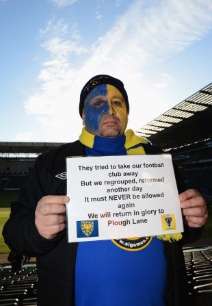 After the original Wimbledon were franchised out to Milton Keynes in 2012, supporters of the original club formed a new team: AFC Wimbledon. In 2012, an AFC fan holds up a placard ahead of the teams' clash in the FA Cup. 