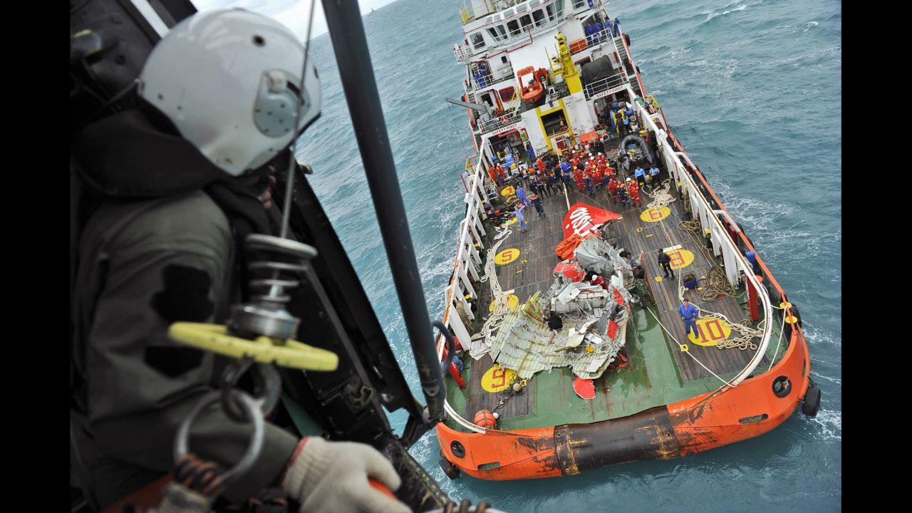 A portion of the plane's tail section is seen on the deck of a rescue ship after it was recovered from the Java Sea on Saturday, January 10.