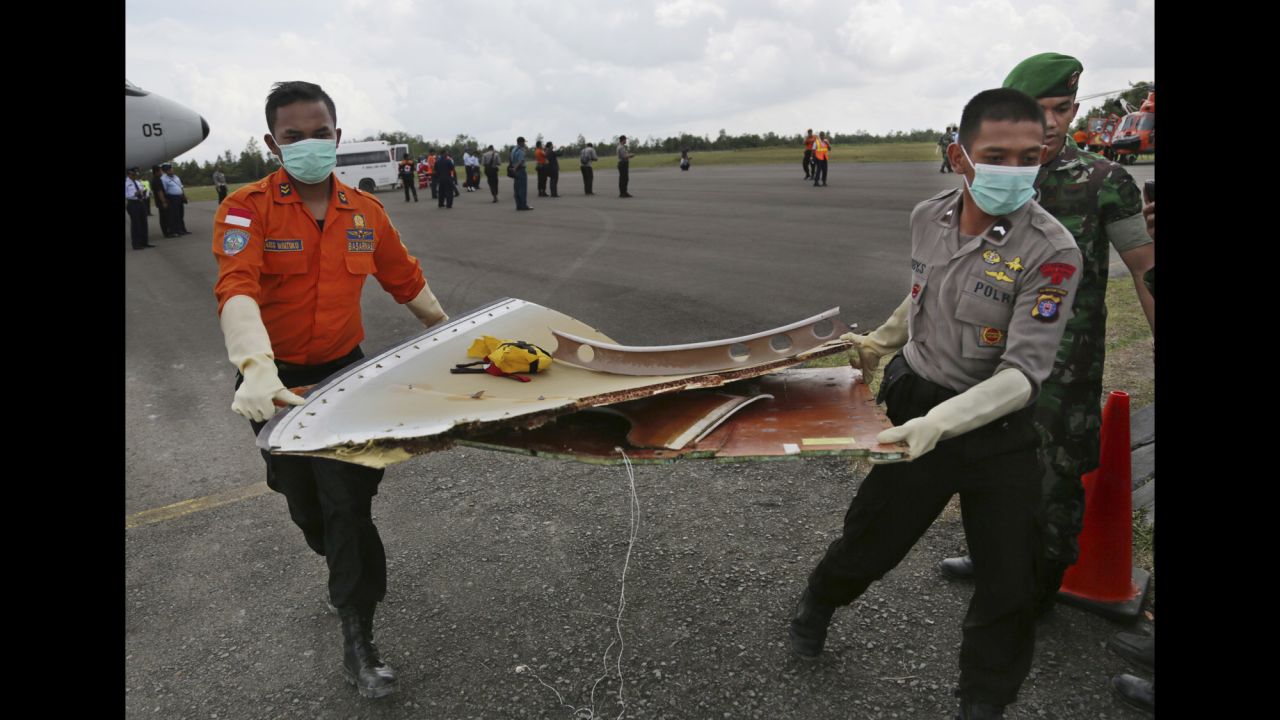 Members of the Indonesian Search and Rescue Agency carry pieces of the jet in Pangkalan Bun on January 9.
