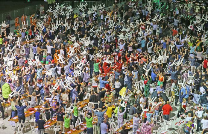 Spectators at an international darts match at the Etihad Stadium in Melbourne caused chaos as they started to throw their plastic chairs into the air.