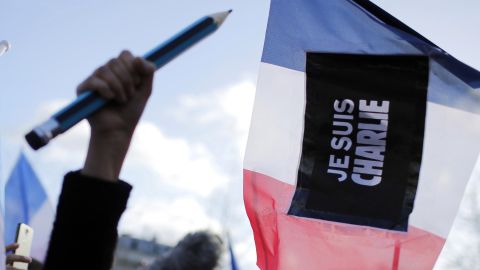 A demonstrator holds up an oversized pencil, a symbol of freedom of expression, beside a banner showing solidarity with Charlie Hebdo, the magazine where 12 people were killed last week.