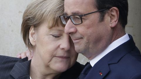 French President Francois Hollande hugs German Chancellor Angela Merkel as she arrives at the Elysee Palace before the rally.