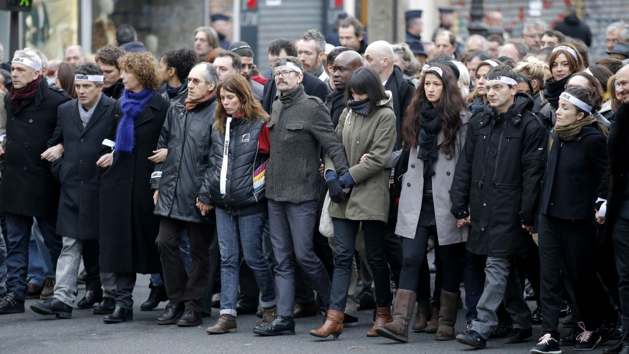Luzier, center with mustache, marches with other survivors of the Charlie Hebdo massacre as well as family members of victims. 