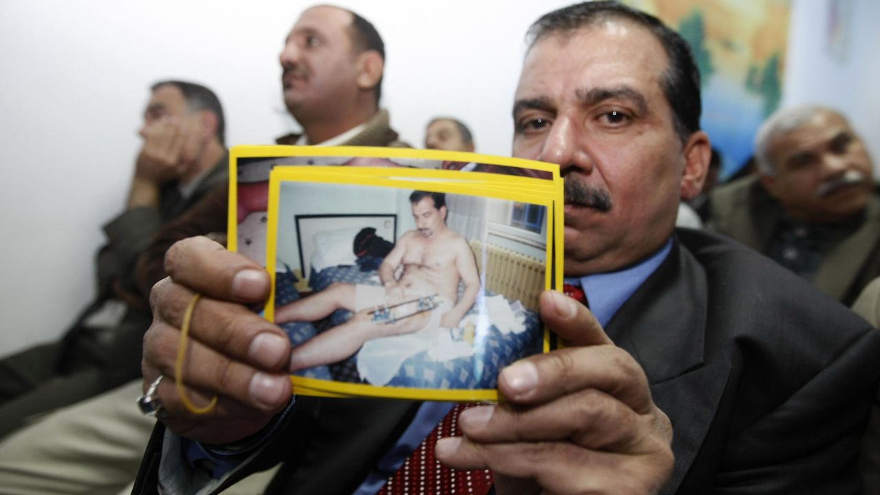 An Iraqi victim of a shooting incident holds up a picture of himself, during a meeting with US Federal Prosecutors to discuss the case against the security firm Blackwater at the central police station close to Nussur Square in central Baghdad on December 13, 2008. 