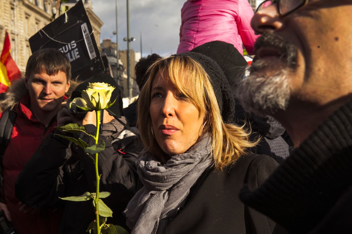 A woman holds a flower at the rally.