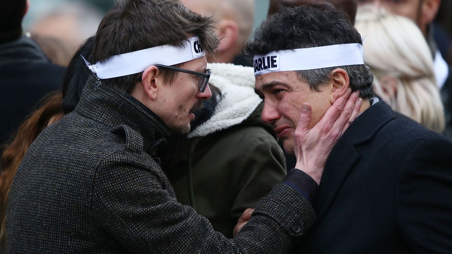 Patrick Pelloux (right), a journalist at Charlie Hebdo, is embraced by Renald "Luz" Lucier (left), a cartoonist at the magazine. 
